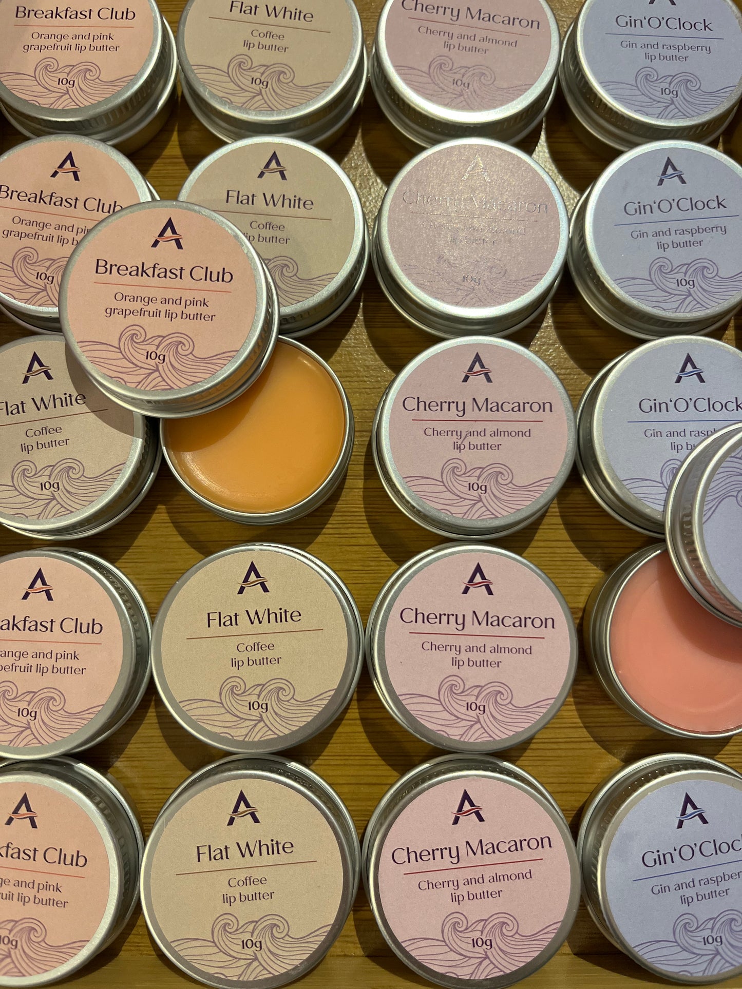 Rows of Ascents lip balms are lined up with two opened.