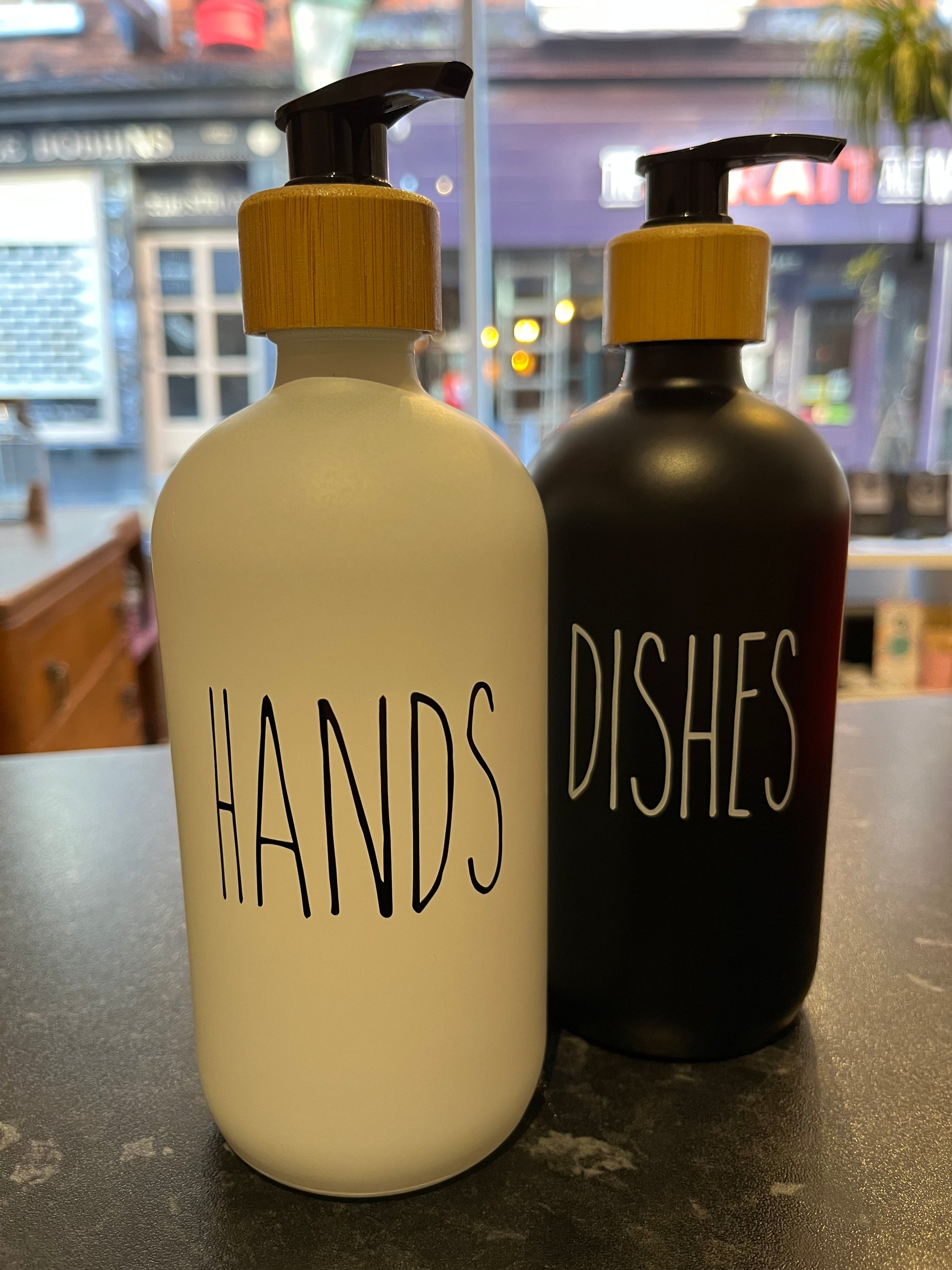 Minimal design glass pump bottles perfect for dispensing hand soap & washing up liquid in opaque black & white glass with a bamboo screw top and black pump. Choose from a black ‘dishes’ or a white ‘hands’ design. Holds 500ml.