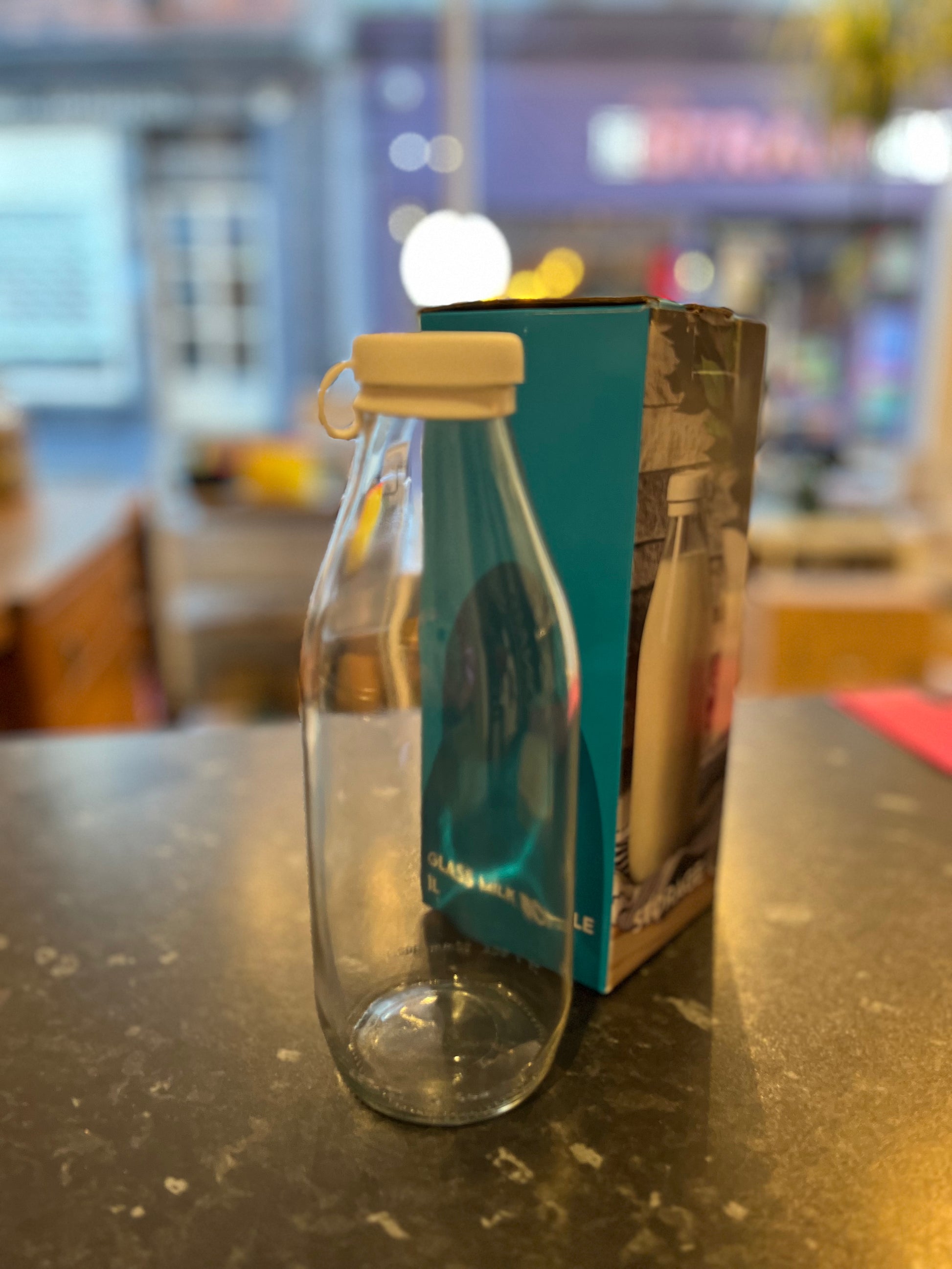 A clear litre glass bottle with a white silicone lid