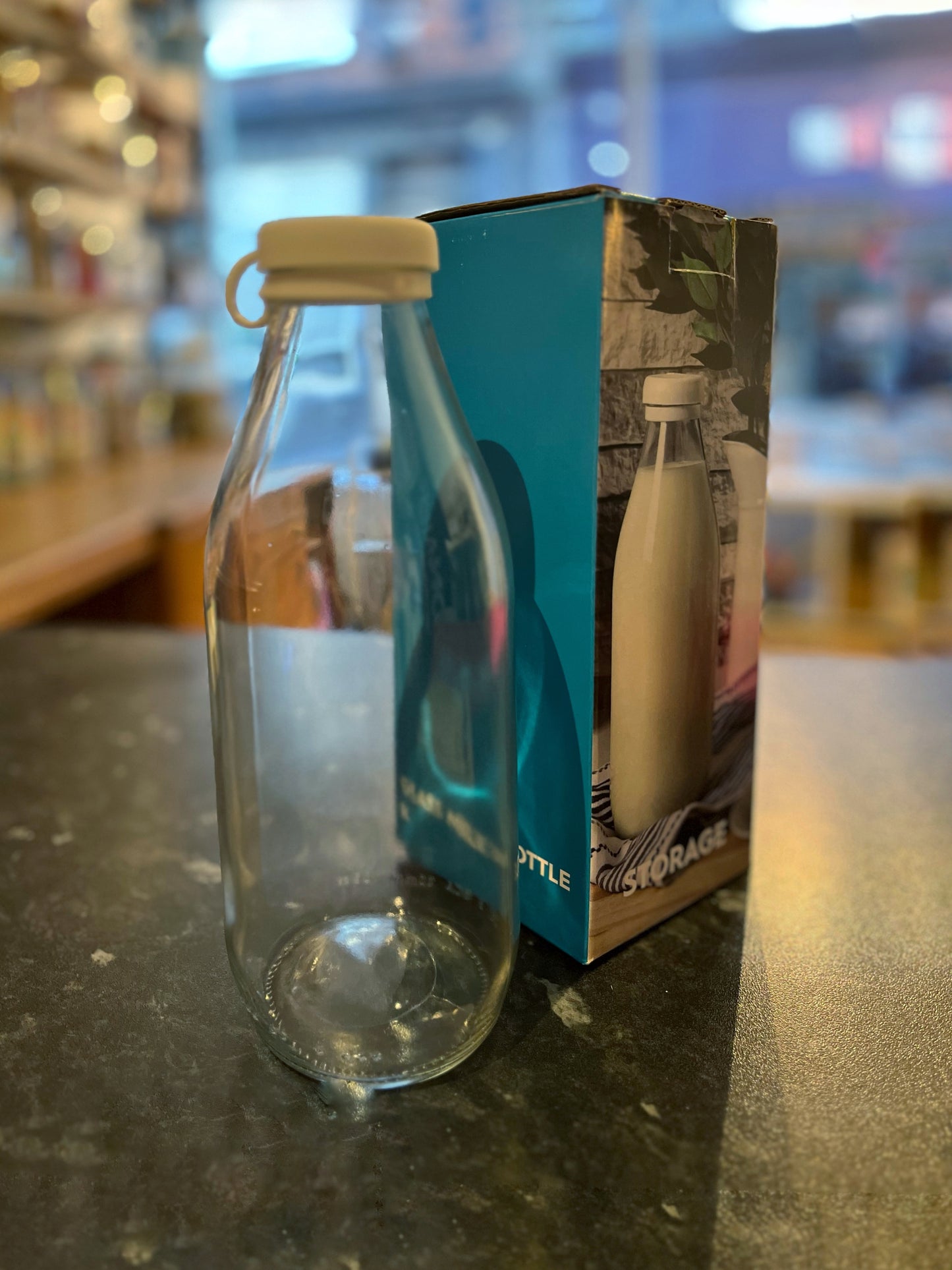 A clear litre glass bottle with a white silicone lid