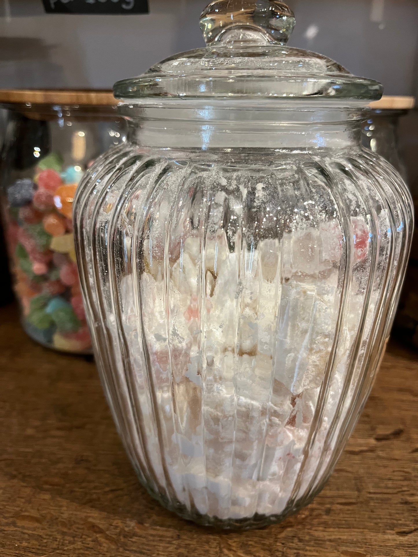 A large fluted glass jar holds pieces of snowy looking turkish delight sweets.