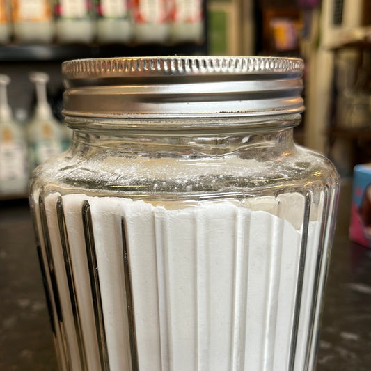 A glass jar filled with Baking Powder.
